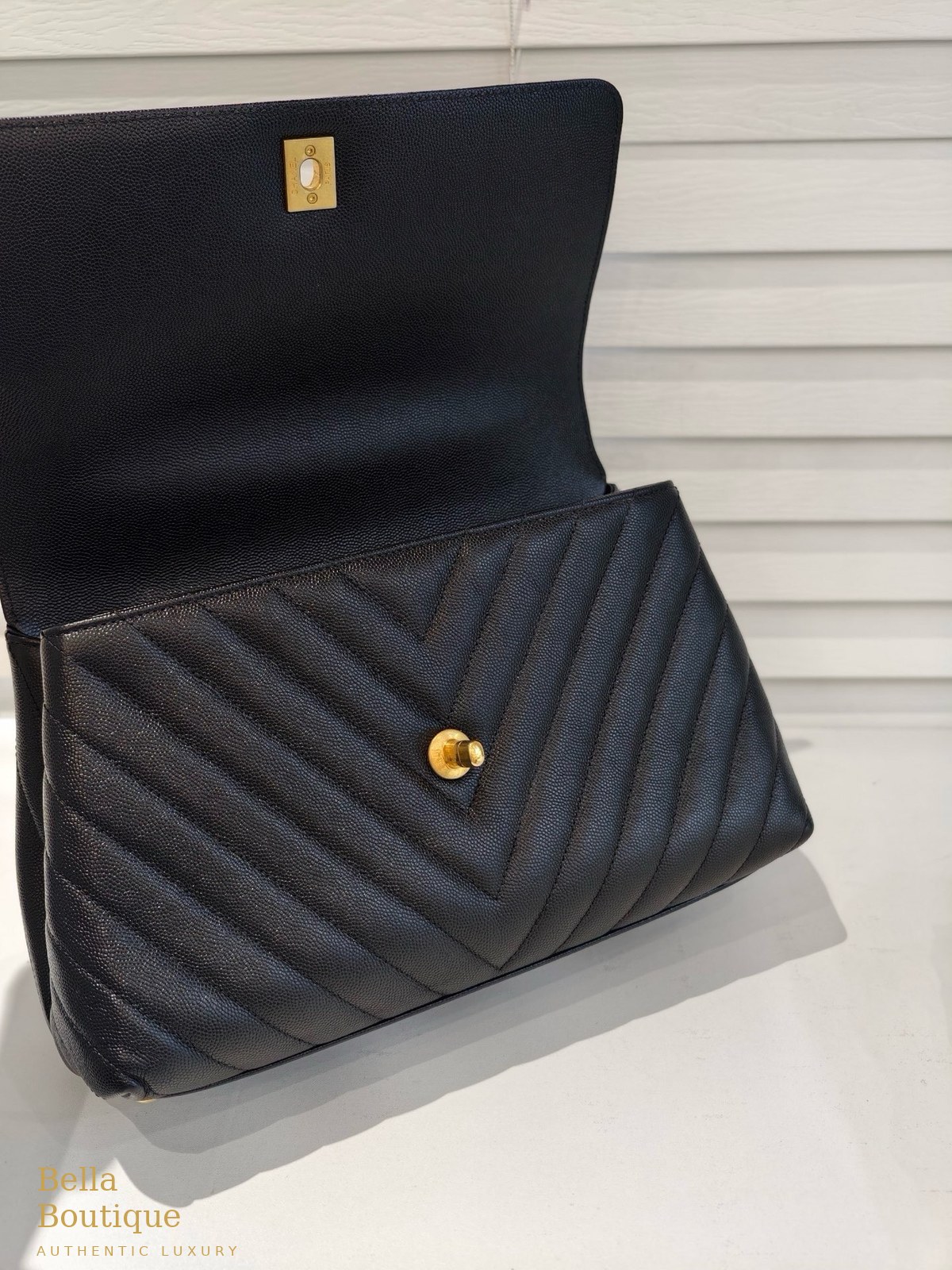 حقيبة شانيل كوكو هاندل ميديوم أصلية — الغطاء مفتوحاً مع لوحة CHANEL PARIS الذهبية